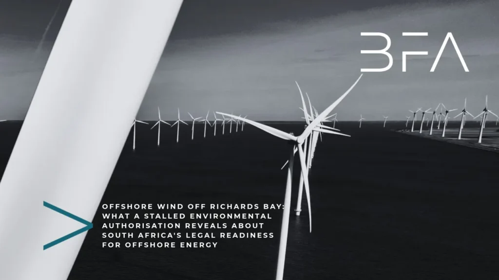Offshore wind turbines in a row at sea under a blue sky